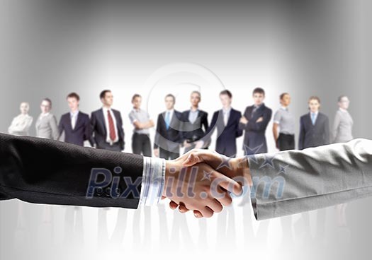 business handshake against white background and standing businesspeople business handshake against white background and standing businesspeople