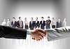 business handshake against white background and standing businesspeople