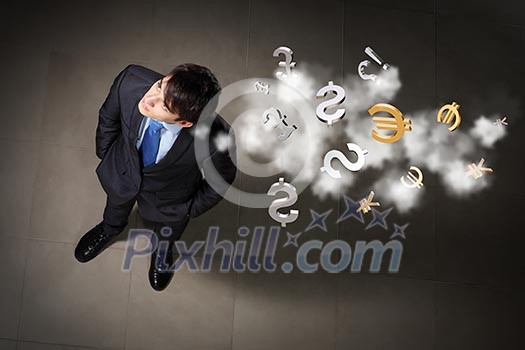 Top view of young businessman making decision currency signs in air Top view of young businessman making decision currency signs in air
