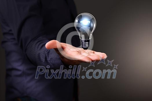 Human hand holding a shining electric bulb Human hand holding a shining electric bulb