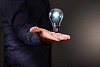 Human hand holding a shining electric bulb