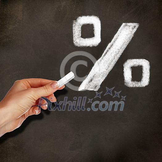 School blackboard and hand with chalk writing percentage symbol on it School blackboard and hand with chalk writing percentage symbol on it