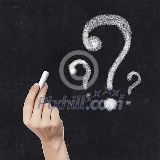 School blackboard and hand with chalk drawing question mark School blackboard and hand with chalk drawing question mark