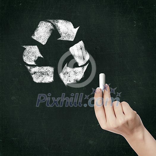 School blackboard and hand with chalk drawing recycle symbol School blackboard and hand with chalk drawing recycle symbol