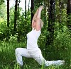 An elderly woman practices yoga in nature. The symbol of healthy lifestyle