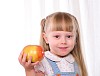 Portrait of a little girl with fruit in their hands.