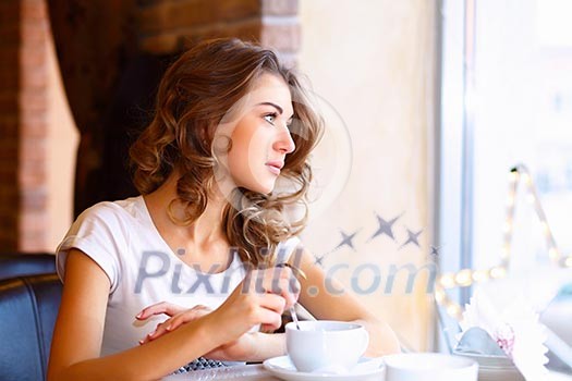 Portrait of young pretty woman sitting in restaurant Portrait of young pretty woman sitting in restaurant
