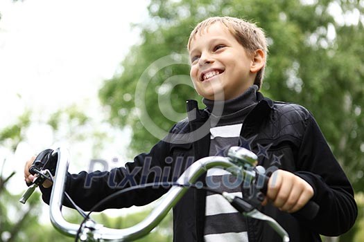 Happy smiling boy on a bicycle in the green park Happy smiling boy on a bicycle in the green park