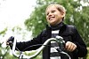 Happy smiling boy on a bicycle in the green park