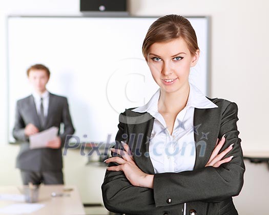young and attractive businesswoman in an office with collegues on the background young and attractive businesswoman in an office with collegues on the background