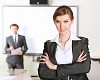 young and attractive businesswoman in an office with collegues on the background