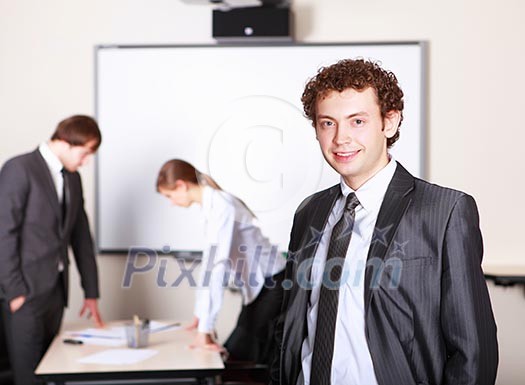 a young smiling businessman in formal wear in office