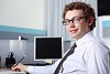 a young smiling businessman in formal wear in office