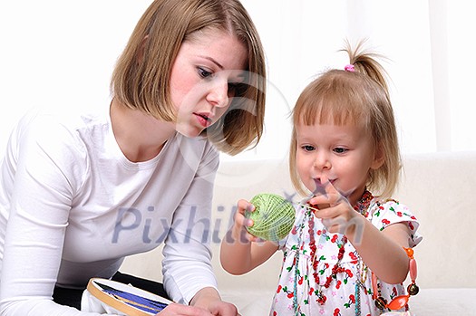 Young mother and her baby daughter spending time together. Dress up in costume jewelry. Young mother and her baby daughter spending time together. Dress up in costume jewelry.