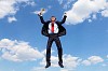 young businessman in a suit with a golden cup against blue sky