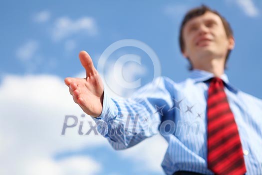 young businessman in a blue shirt and red tie giving a hand for a handshake young businessman in a blue shirt and red tie giving a hand for a handshake