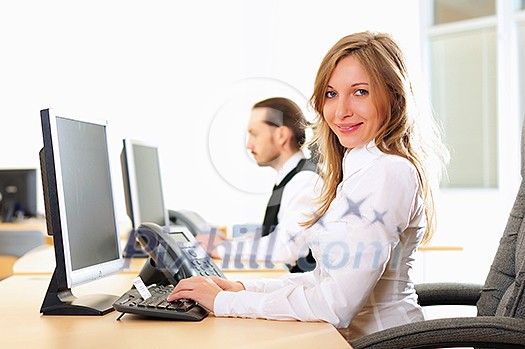 A young girl in his office at his workplace works at the computer A young girl in his office at his workplace works at the computer