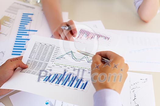 financial and business documents on the table and human hands