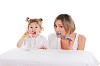 young mother and her young daughter brush their teeth on a white background