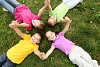 Group of children lying on the grass in the summer park