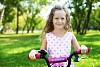 Little happy girl having fun in green summer park