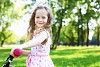 Little happy girl having fun in green summer park