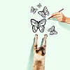 Image of siamese cat catching drawn butterfly