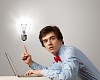 Young troubled man sitting at table with laptop