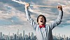 Image of businessman hanging on rope against city background