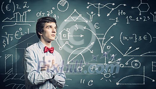 Image of thoughtful male student holding notebook in classroom Image of thoughtful male student holding notebook in classroom