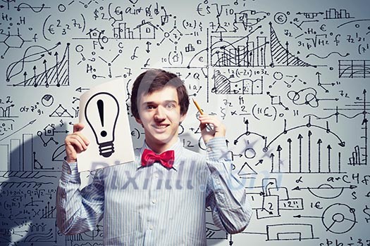 Image of thoughtful male student holding notebook in classroom Image of thoughtful male student holding notebook in classroom
