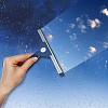 Hand cleaning window with blue sky and white clouds