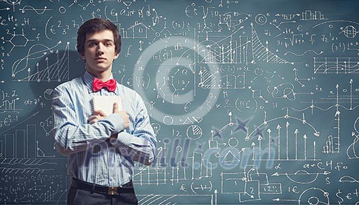 Image of thoughtful male student holding notebook in classroom Image of thoughtful male student holding notebook in classroom