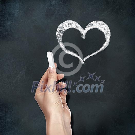 School blackboard and human hand with chalk drawing heart symbol School blackboard and human hand with chalk drawing heart symbol