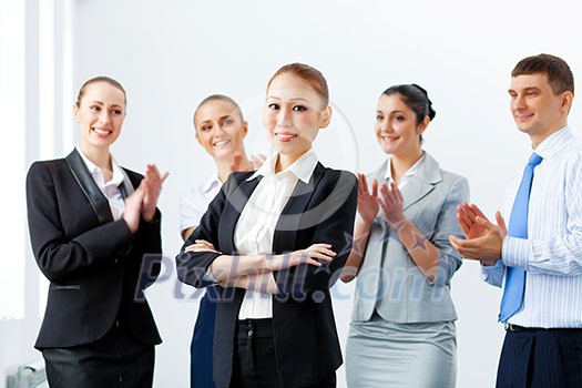 Young asian businesswoman smiling with colleagues applauding joyfully at background Young asian businesswoman smiling with colleagues applauding joyfully at background