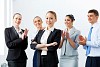 Young asian businesswoman smiling with colleagues applauding joyfully at background