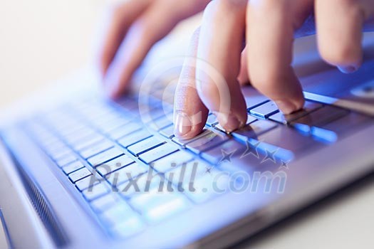 Click! Hands of a man on a keyboard with blue backlighting. Click! Hands of a man on a keyboard with blue backlighting.