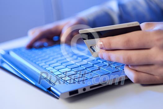 Click! Hands of a man on a keyboard with blue backlighting. Click! Hands of a man on a keyboard with blue backlighting.