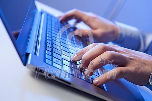 Click! Hands of a man on a keyboard with blue backlighting. Click! Hands of a man on a keyboard with blue backlighting.