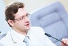 Image of young businessman sitting at table at business meeting
