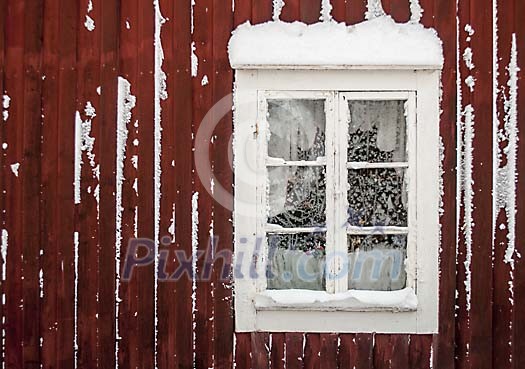 A window on a red house covered in frost and snow A window on a red house covered in frost and snow