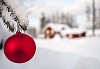 A red Christmas ball in front of a house