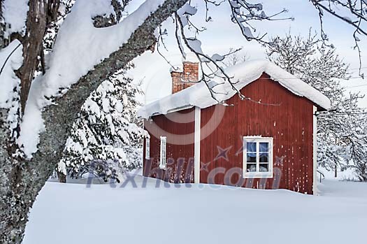A snow covered red wooden house A snow covered red wooden house