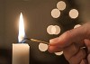 Hand lighting a candle with a match