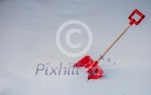 A red snow shovel in the snow A red snow shovel in the snow