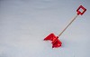 A red snow shovel in the snow