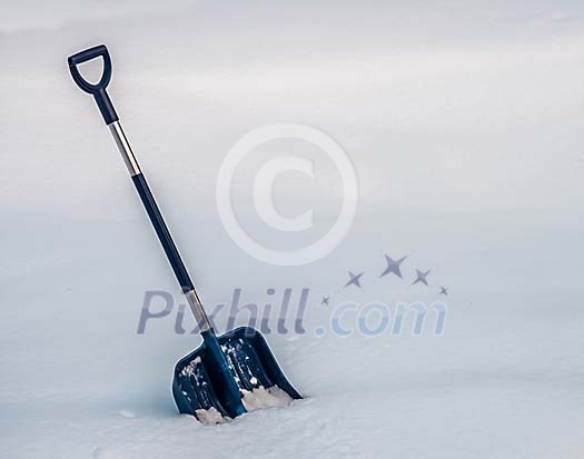 A blue snow shovel in the snow A blue snow shovel in the snow