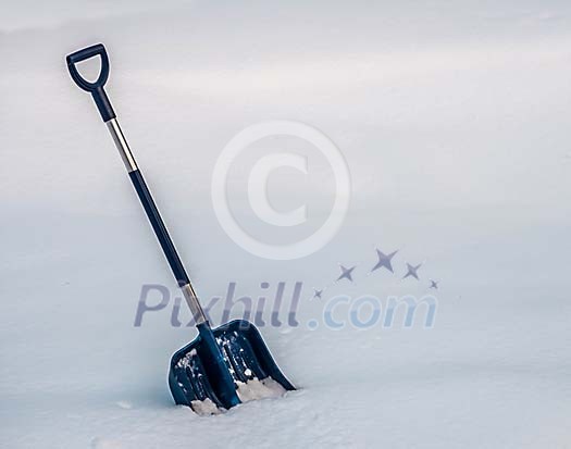 A blue snow shovel in the snow