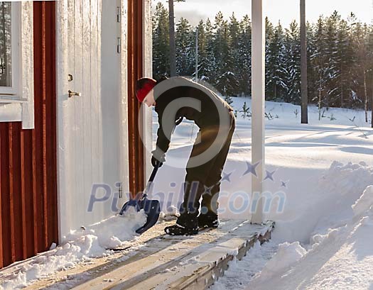 Woman shovelling snow from the porch Woman shovelling snow from the porch