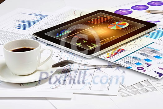 Image of cup of coffee and ipad laying on business documents Image of cup of coffee and ipad laying on business documents